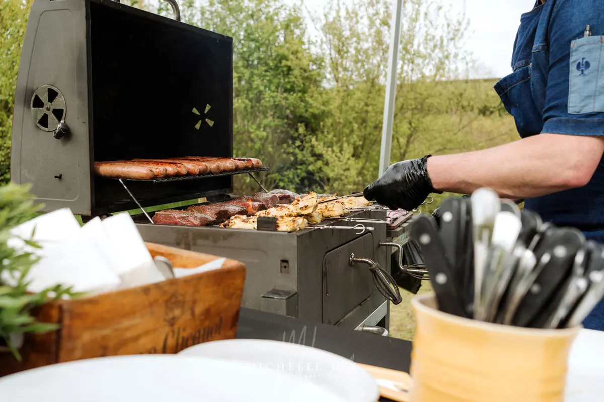 Dave Rees of Frisky Pheasant cooking over an open flame at Tree Top Escape wedding