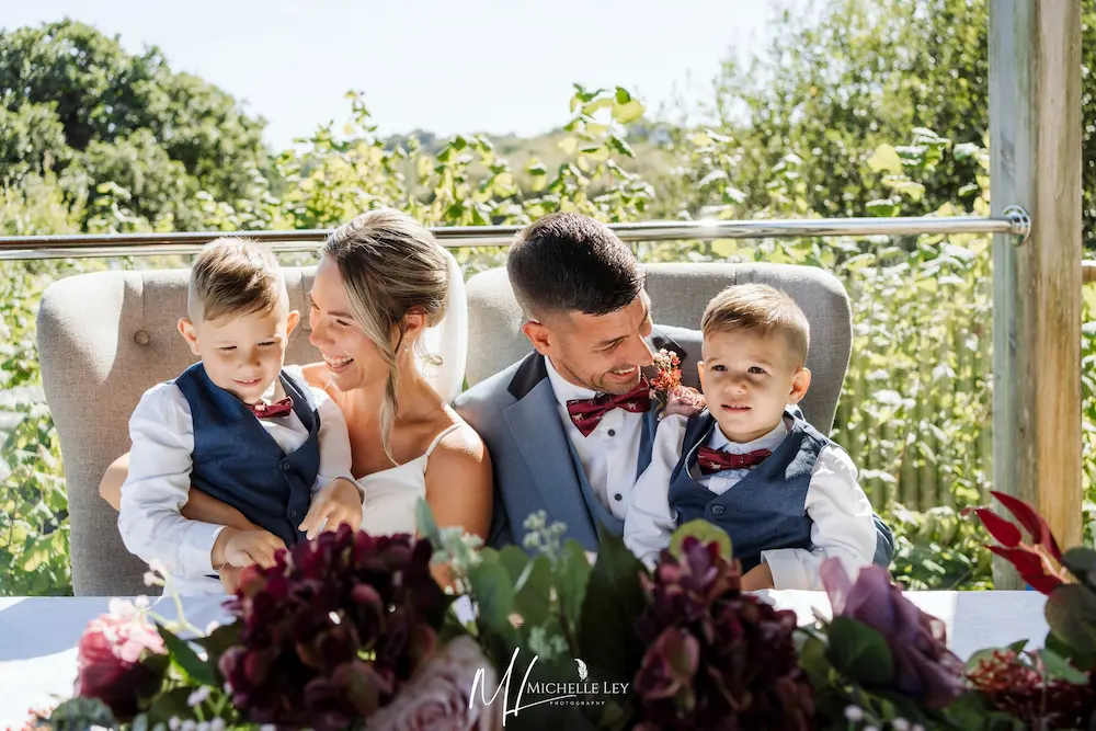 A groom sharing a joyful moment with children at a family wedding at Tree Top Escape, Devon