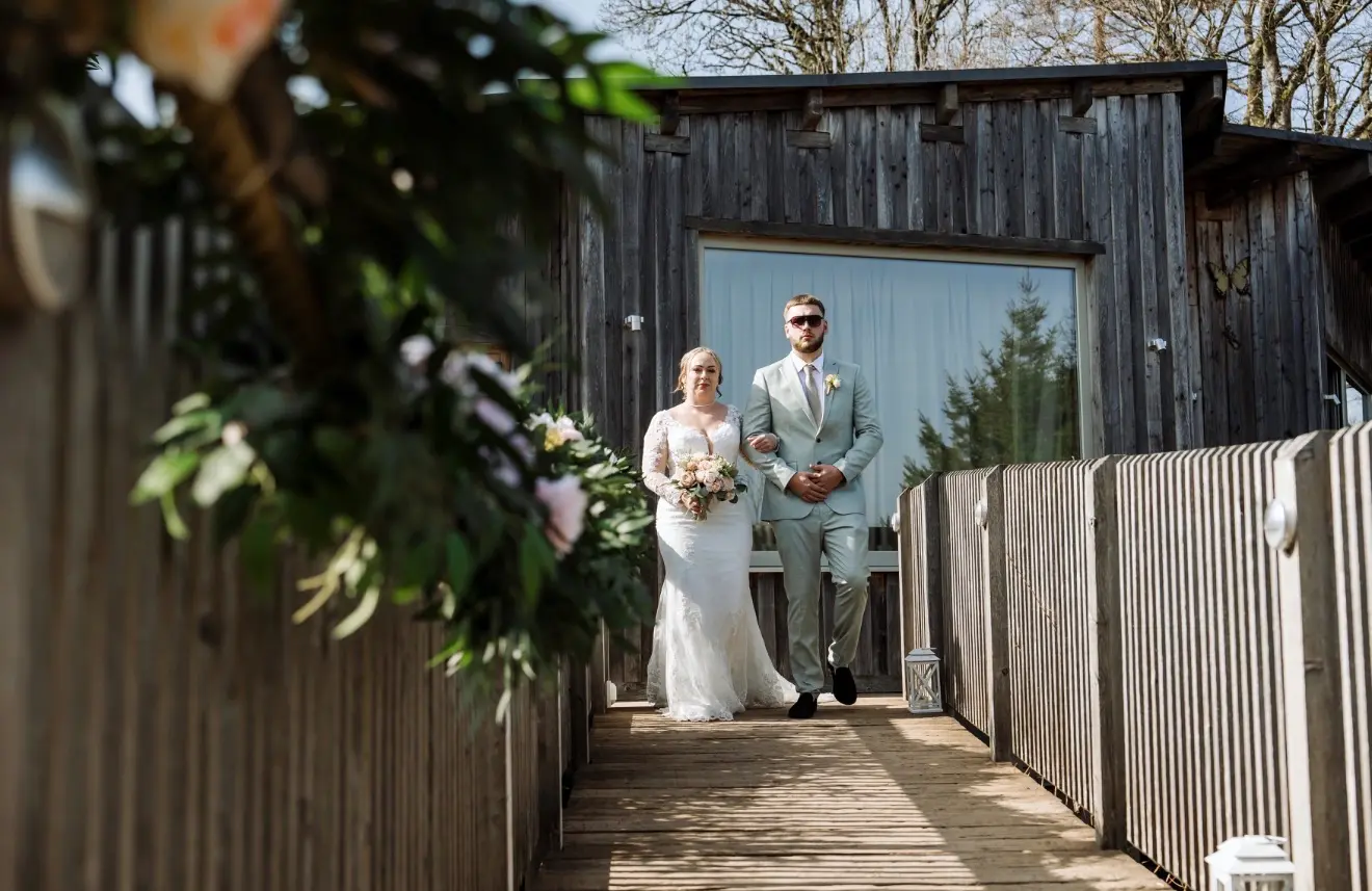 Kelly and Ryan walking to their ceremony at Tree Top Escape, Devon