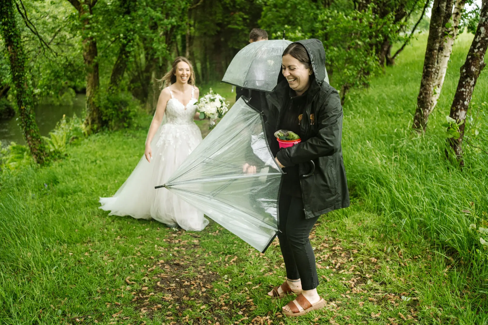 Nicola helping a bride with her dress in the rain at Tree Top Escape, Devon