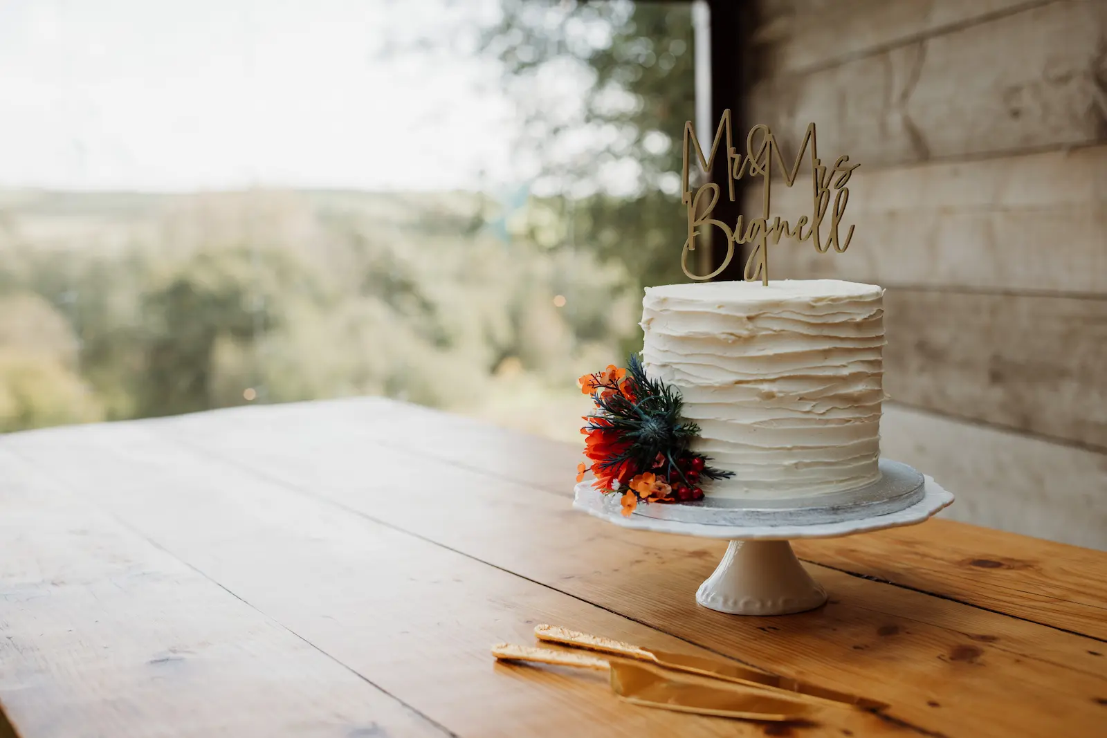 Three-tier wedding cakes by Old Parlour Bakes, decorated with fresh flowers and a Mr and Mrs topper — North Devon wedding supplier